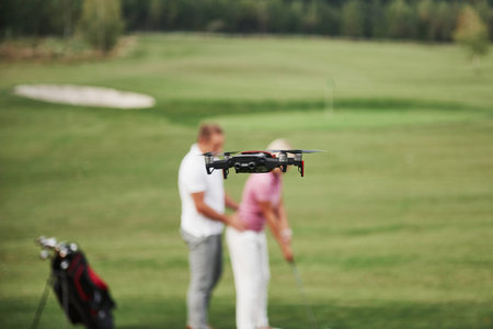 Group of stylish friends on the golf course learn to play a new game. Shooting is conducted from the...