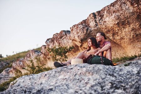 Dreaming mood. Two person sitting on the rock and watching gorgeous nature.の写真素材