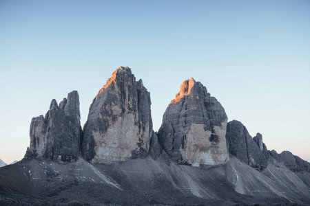 Beautiful sunlight on the top of rocks. Three peaks Tre Cime mountains in the morning with clear sky...