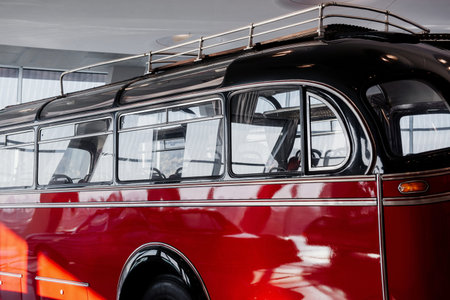 Vintage red bus parked indoor. White room with windows. Car show.