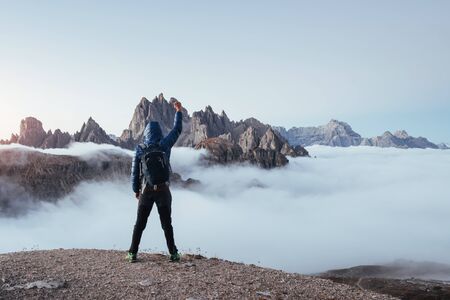 Extreming standing on the edge. Touristic man raised his hands up on the beautiful daylight...