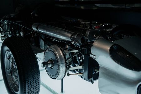 A close up, side view of grey cutted retro sport coupe cabriolet with right headlight, multi spoke disc on lighted floor.の写真素材