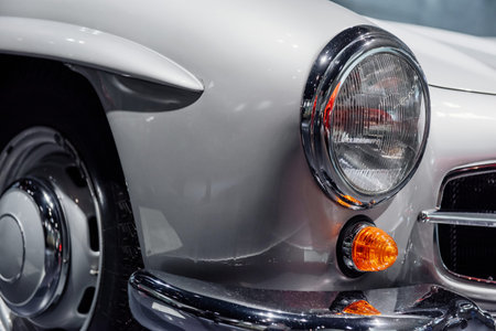 Red vintage automobile on a car show. Close up view on headlights.
