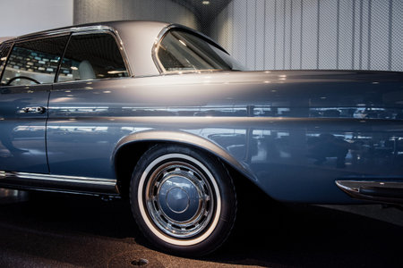 Photo from the side. The rear view of the polished blue car in car show standing on the stand.