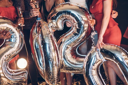 People holding ballons in the shape of numbers of new 2020 year.