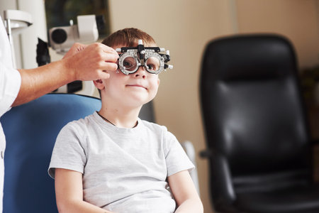 Checking different lenses. Child sitting in the doctors cabinet and have tested his visual acuity.の写真素材