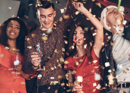 Good mood. Air in the confetti. Four good friends in the good clothes are on the party of new year.の写真素材