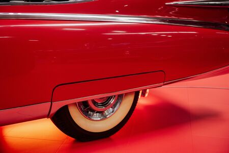 SINSHEIM, GERMANY - OCTOBER 16, 2018: Technik Museum. Close up photo. Side part of the red vintage car. Rear creamy colored wheel.のeditorial素材