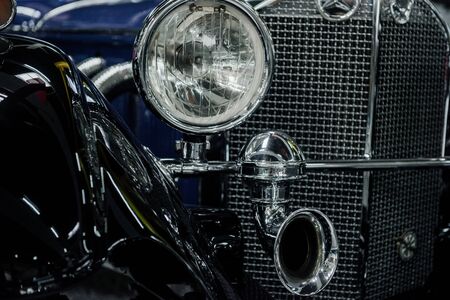 SINSHEIM, GERMANY - OCTOBER 16, 2018: Technik Museum. Radiator grid, headlights and tubes on the front of retro styled car.のeditorial素材