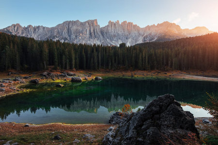 Plants are blooming in the water, you can see it by green color. Autumn landscape with clear lake,...
