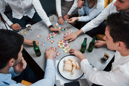 Top view. Relaxing with game. Celebrating successful deal. Young office workers sitting near the...