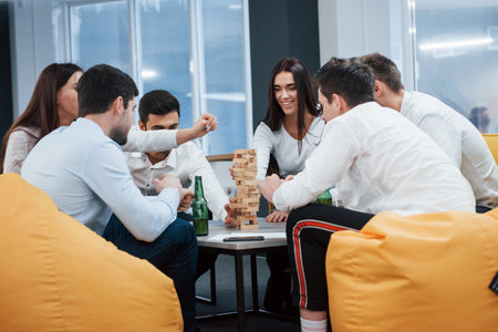 Nice evening in good company. Celebrating successful deal. Young office workers sitting near the...