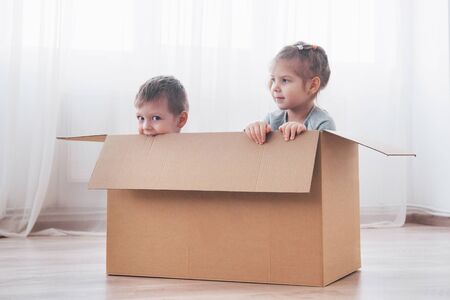 Two a little kids boy and girl just moved into a new home. Concept photo .. Children have funの写真素材