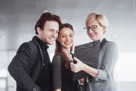 business, technology and office concept - smiling female boss talking to business team.