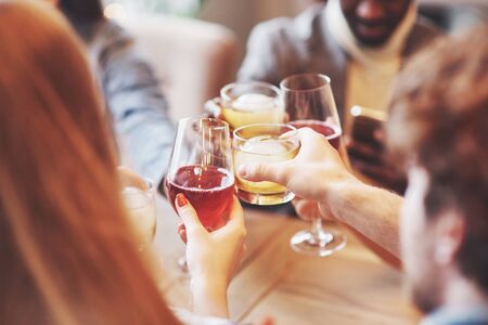 Hands of people with glasses of whiskey or wine, celebrating and toasting in honor of the wedding or other celebration.の写真素材