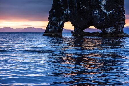Hvitserkur is a spectacular rock in the sea on the Northern coast of Iceland. Legends say it is a petrified troll. On this photo Hvitserkur reflects in the sea water after the midnight sunset.の写真素材