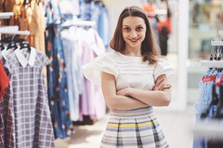 Smiling shop manager in front of her boutique.