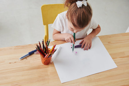 Some kind of art techique. Cute little girl in art school draws her first paintings by pencils and...