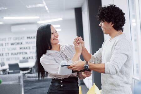 They win that competition. Cheerful coworkers in a modern office smiling when doing their job.の写真素材