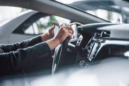 Particle view. Businessman tests his new modern car. Black luxury interior of nice vehicle.の写真素材