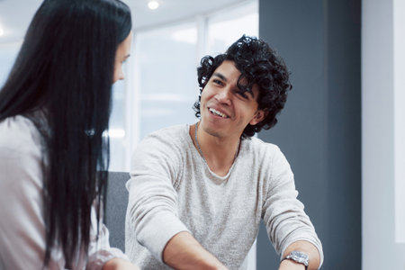 Great idea. Young professionals. Cheerful coworkers in a modern office smiling when doing their job...