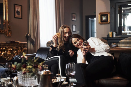 Two female friends having nice time in beautiful luxury modern restaurant.