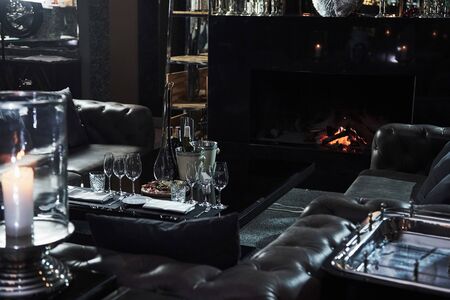 Calm place in the restaurant with table full of champagne glasses and beautiful fireplace.の写真素材