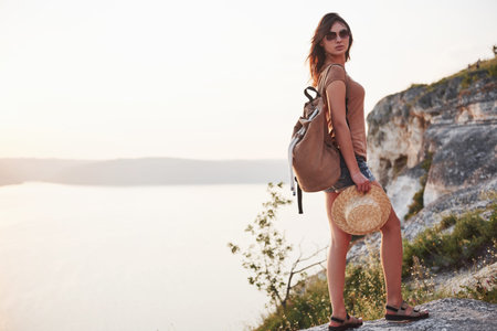 Young tourist woman on the top of the mounting and looking at a beautiful bay landscape. Hiking...