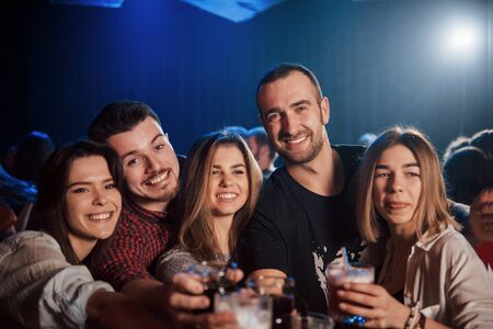 Drink all night. Group of young friends smiling and making a toast in the club.の写真素材
