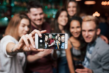 Picture of girl taking photo of herself and her friends at the party.の写真素材