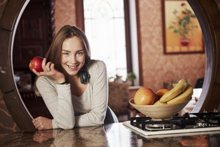 Gorgeous girl. Pretty young woman standing in the modern kitchen near gas stove.の写真素材