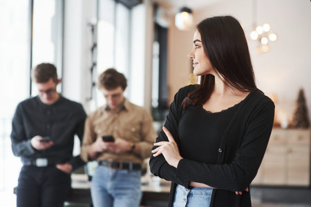 Confident happy girl. Group of students in eyewear standing in the learning room at daytime.の写真素材