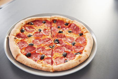 Time for dinner. Picture of prepared delicious pizza with sausage rings and olives.の写真素材