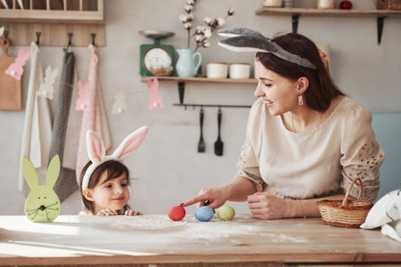 Good looking family members. Mother and daughter in bunny ears at easter time have some fun in the...