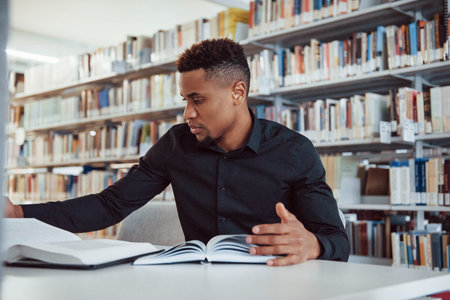 Having research. African american man sitting in the library and searching for some information in...