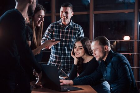 Nice to meet you again, you came on time. Team of young business people works on their project at night time in the office.の写真素材