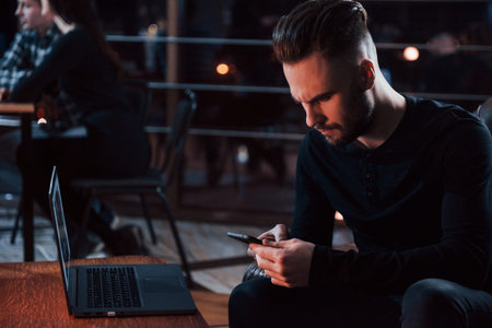 Money is too important for this guy. Stylish young businessman works alone in the office at...