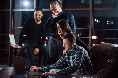 Just some rest after job. Team of young business people works on their project at night time in the...