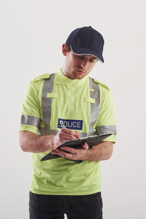Affairs that need special attention. Policeman in green uniform stands against white background in...