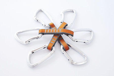 First needed equipment for the safety. Many of the multi colored carabiners on lying on the white...
