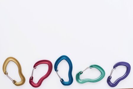Five objects. Many of the multi colored carabiners on lying on the white table.の写真素材