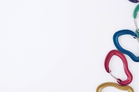On edge of the picture. Many of the multi colored carabiners on lying on the white table.の写真素材