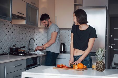 Conversation between two people. Young couple in the modern kitchen at home at their weekend time in the morning.の写真素材