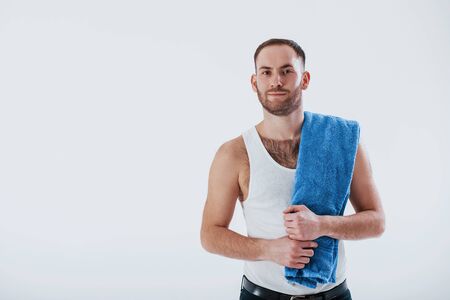Healthcare conception. Man with blue towel stands against white background in the studio.の写真素材