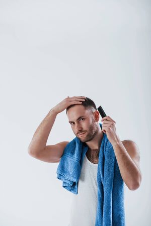 Preparing to the important meeting. Man with blue towel stands against white background in the studio.の写真素材
