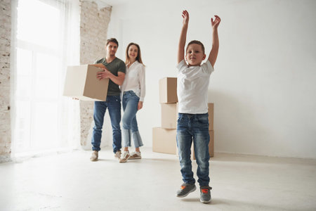 Look at me. Playful mood from the kid. Family have removal into new house. Unpacking moving boxes.