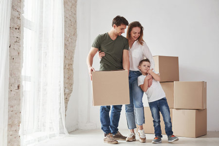 Happy together. Family have removal into new house. Unpacking moving boxes.の写真素材