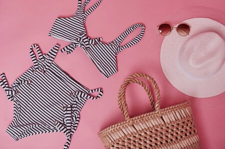Bikini on the pink colored table. Group of objects for the traveling and vacations.の写真素材