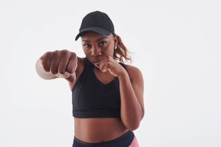 Its boxing time. Young beautiful afro american woman in the studio against white background.の写真素材