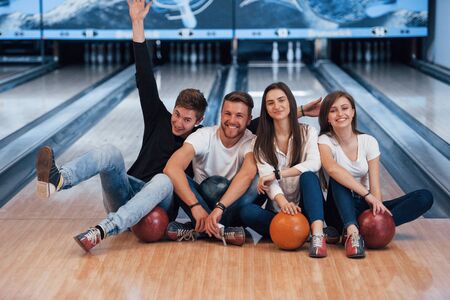 Positive emotions. Young cheerful friends have fun in bowling club at their weekends.の写真素材